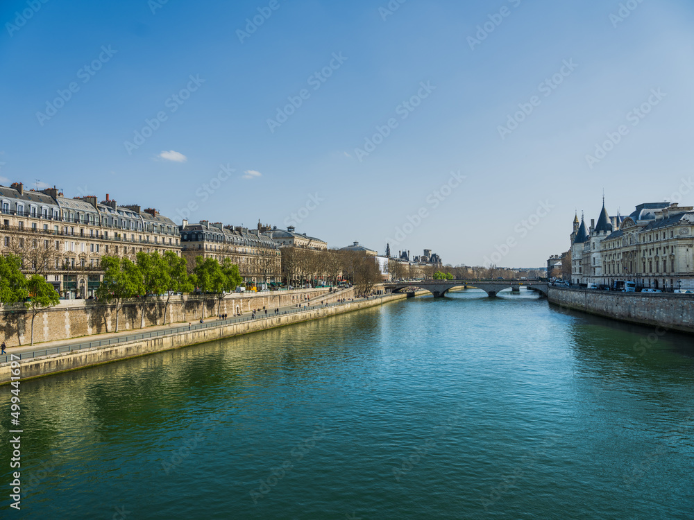 Pedestrian walkway on the Seine river bank with Pont au Change and Louvre palace