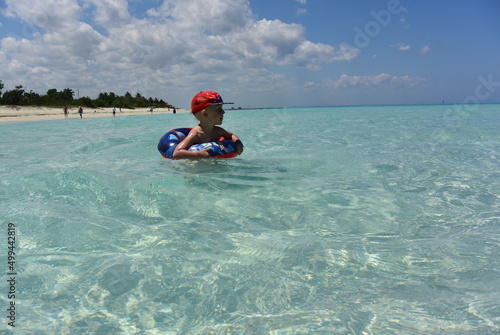 The coast of Cuba, Varadero, a Cuban boy swims in the azure waters of the Atlantic Ocean. © Виктория Балобанова