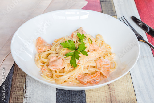 tagliatelli pasta with salmon on white bowl photo