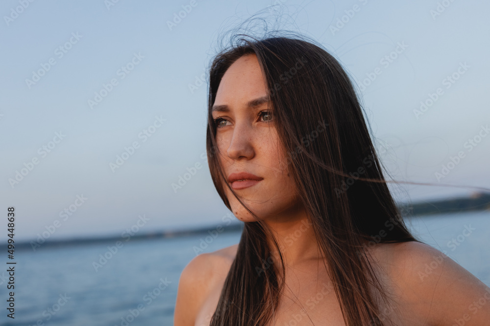 portrait of beautiful brunette woman on blue sea background portrait of beautiful brunette woman on blue sea background