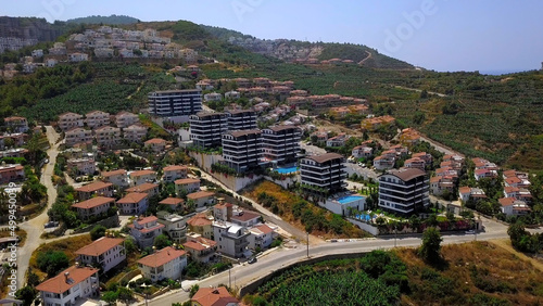 Resort view from a helicopter.Clip. A beautiful resort area with hotels, green parks, views of sports fields and large green mountains in the background photo