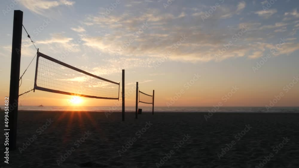 Volleyball net silhouette on beach court at sunset, California coast, USA. Sport field for volley ball game. Twilight sky background, sundown on Mission beach, San Diego, ocean shore near Los Angeles. Volleyball net silhouette on beach court at sunset, California coast, USA. Sport field for volley ball game. Twilight sky background, sundown on Mission beach, San Diego, ocean shore near Los Angeles.