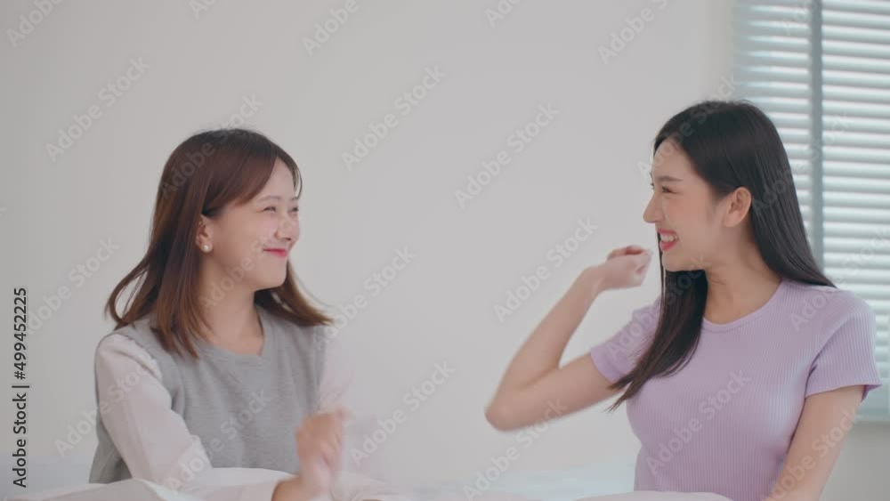 Excited LGBT Asian ladies Couple Use smartphone , Do High-Five in Celebration, while Sitting on the bedroom room of their Apartment. Girlfriends Talk, Shop on Internet, Choose Product to Order Online Excited LGBT Asian ladies Couple Use smartphone , Do High-Five in Celebration, while Sitting on the bedroom room of their Apartment. Girlfriends Talk, Shop on Internet, Choose Product to Order Online