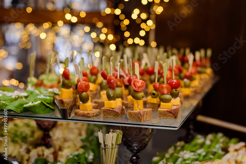 Canapes on wooden skewers on a buffet or banquet. Catering.
