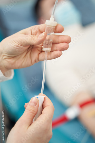 Nurse holding equipment for infusion for man in bed