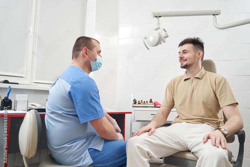 Obraz premium Cheerful man during consultation with doctor in clinic