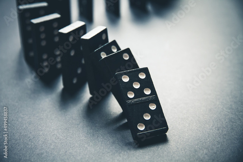 Black dominoes chain on table background photo