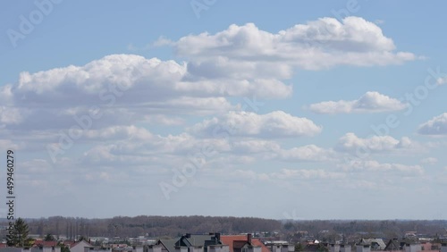 Aerial view of horizon line of small polish town, spring trees growing in forests, skyline, blue clear sky, white fluffy clouds. 4k video landscape of sunny spring day in Poland photo