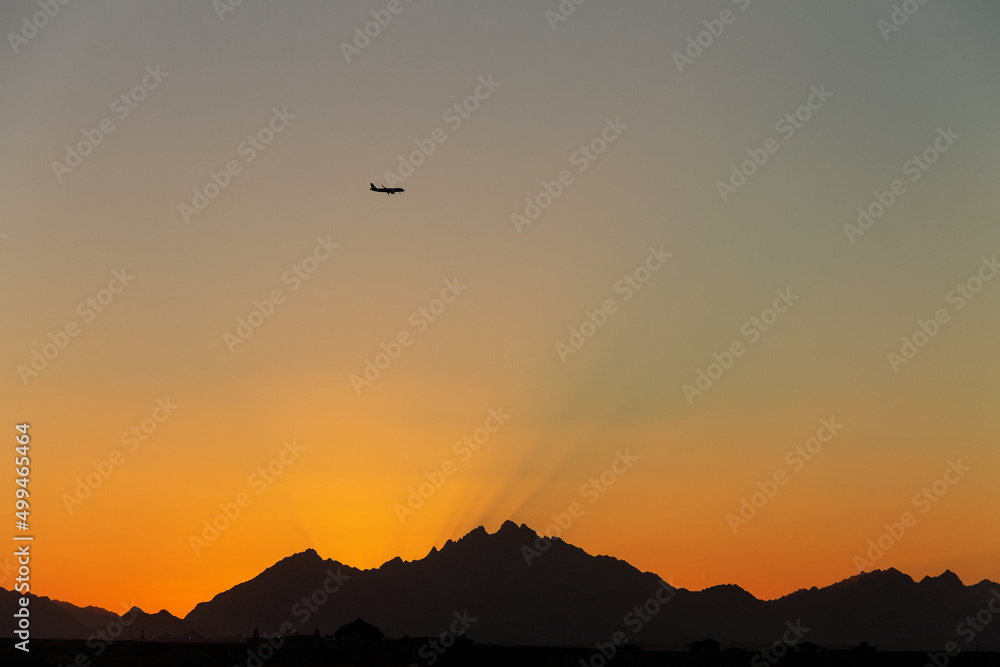 golden sunset on the background of dark silhouettes of mountains