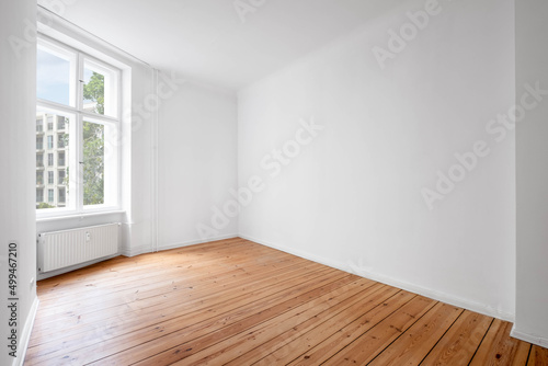 white room in empty flat with window and wooden floor