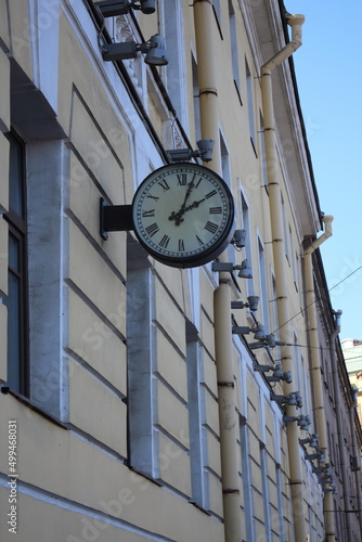 round clock on the facade of a building in the city