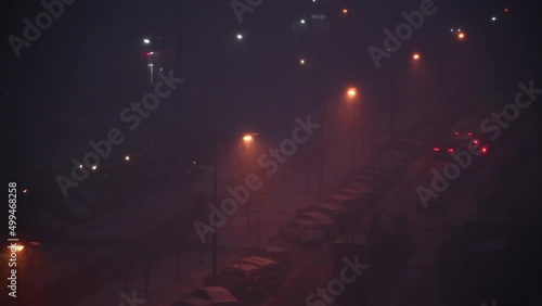 Selective focus. Heavy snow during blizzard with street lamp light by road at winter night. Low visibility. Real time 4K resolution video. Winter weather forecast theme.