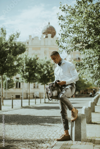 Young African American businessman waitng for a taxi on a street photo