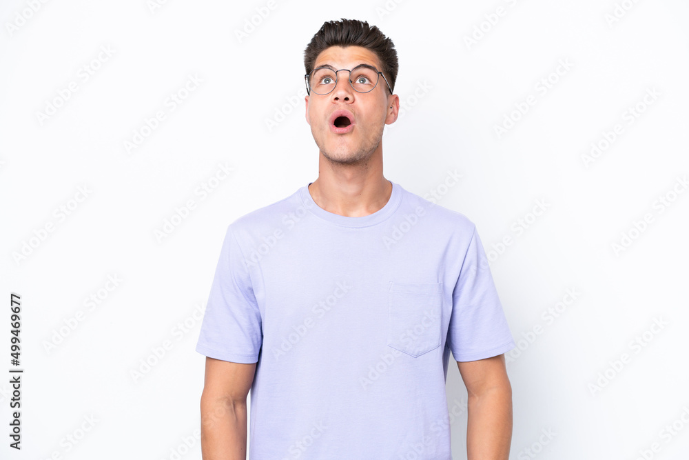 Young caucasian man isolated on white background looking up and with surprised expression Young caucasian man isolated on white background looking up and with surprised expression