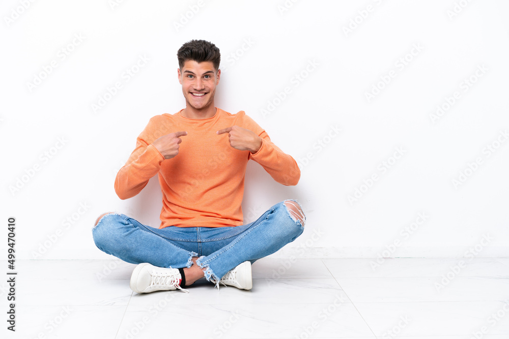 Young man sitting on the floor isolated on white background with surprise facial expression Young man sitting on the floor isolated on white background with surprise facial expression