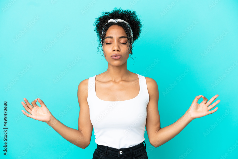 Young latin woman isolated on blue background in zen pose