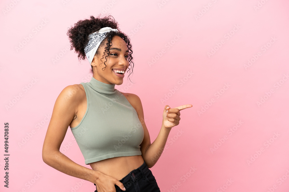 Young latin woman isolated on pink background pointing finger to the side and presenting a product Young latin woman isolated on pink background pointing finger to the side and presenting a product