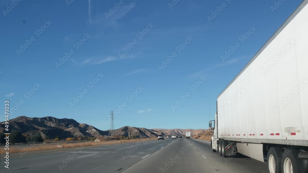 Lorry truck or semi-trailer on highway, freight cargo transportation in California USA. White container hauling or trucking on freeway road. Commercial transport logistics, van haulage. Cars driving. Lorry truck or semi-trailer on highway, freight cargo transportation in California USA. White container hauling or trucking on freeway road. Commercial transport logistics, van haulage. Cars driving.