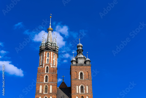 Two Basilica Basilica Towers on Main Market Square Krakow On Sunny Day Under Blue Sky With White Clouds