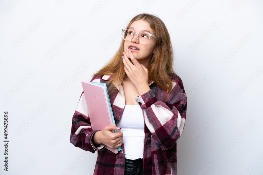 Teenager student Russian girl isolated on white background looking up while smiling Teenager student Russian girl isolated on white background looking up while smiling