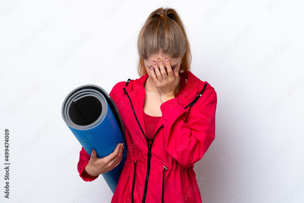 Obraz premium Teenager girl going to yoga classes while holding a mat isolated on white bakcground with tired and sick expression