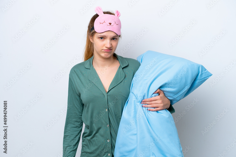 Teenager Russian girl isolated on white background in pajamas and with sad expression Teenager Russian girl isolated on white background in pajamas and with sad expression