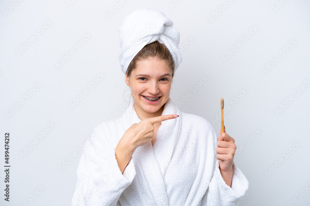 Teenager Russian girl brushing teeth isolated on white background and pointing it Teenager Russian girl brushing teeth isolated on white background and pointing it