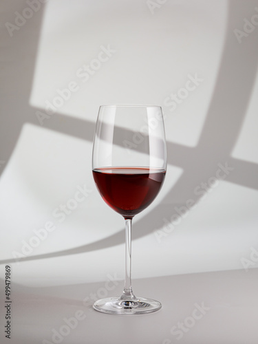 Still life with glass of red wine on white background, copy space