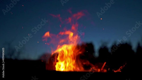 Flammen vom Lagerfeuer lodern an einer Feuerstelle bei Nacht vor dem Himmel  photo