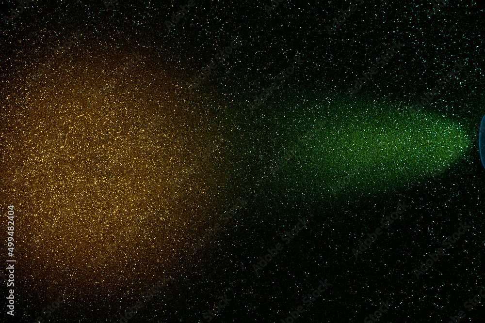 On a dark green background in fine grain, a golden cloud of light and a ray of green light