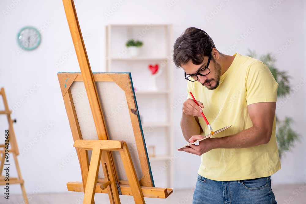 Young man enjoying painting at home Young man enjoying painting at home