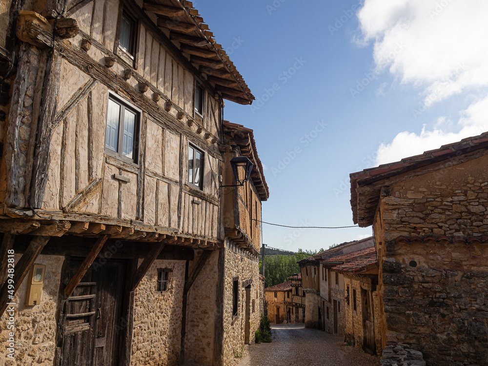 Vistas soleadas de casas de arquitectura medieval de madera,  en el pueblo de Calatañazor en España, província de Soria, en el verano de 2021
