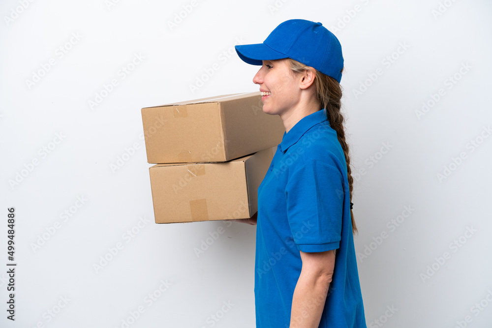 Delivery caucasian woman isolated on white background laughing in lateral position Delivery caucasian woman isolated on white background laughing in lateral position