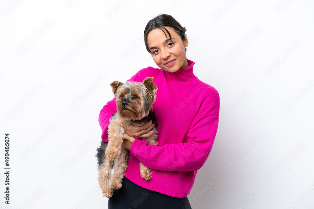 Young hispanic woman holding a dog isolated on white background with happy expression