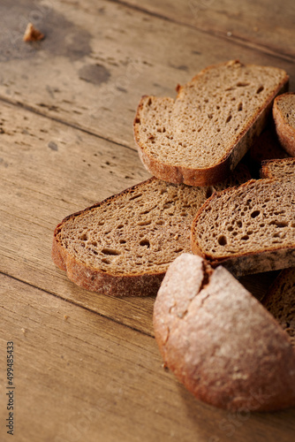 Bread, traditional homemade bread cut into slices on a rustic wooden background, close-up.