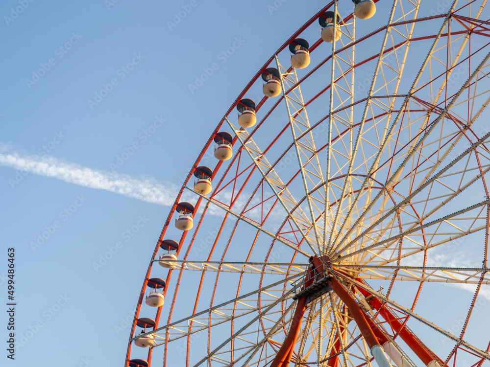 Ferris wheel against the sky. Amusement park by the sea. Rest zone. Round mechanism. Height lovers.