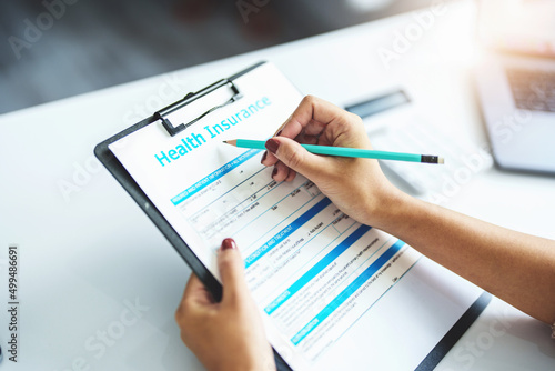 Fotografie insurance claim, contract, agreement, customer holding a pen to read health insurance requirements before signing contract documents