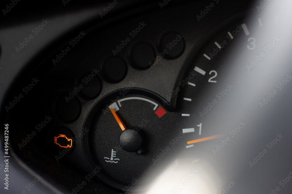 Naklejka premium Yellow lit engine error sign on car dashboard close up