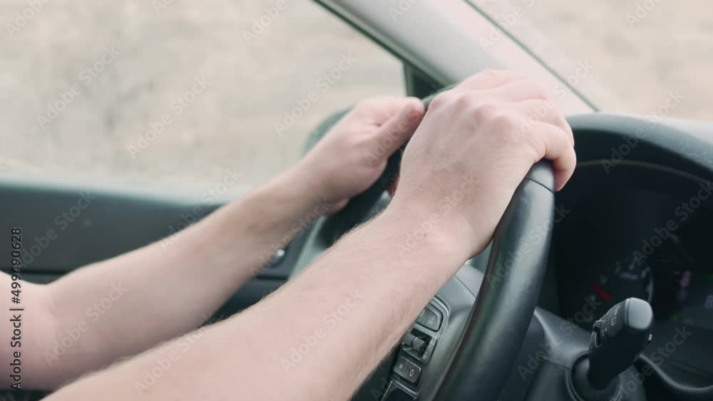 Men's hands on the steering wheel of the car while driving. Men's hands on the steering wheel of the car while driving.