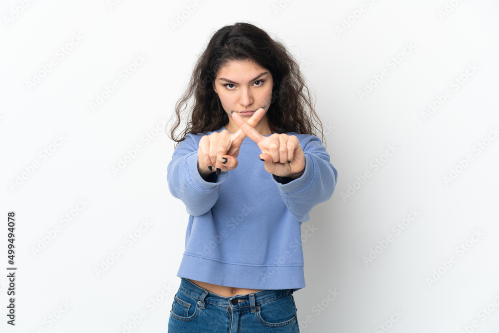 Teenager Russian girl isolated on white background making stop gesture with her hand to stop an act Teenager Russian girl isolated on white background making stop gesture with her hand to stop an act