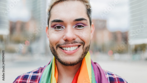 Gay man with makeup on wearing rainbow flag outdoor - LGBTQ drag queen concept