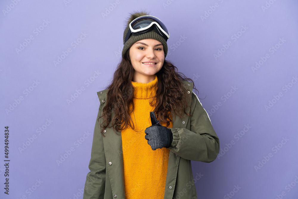 Teenager Russian girl with snowboarding glasses isolated on purple background giving a thumbs up gesture