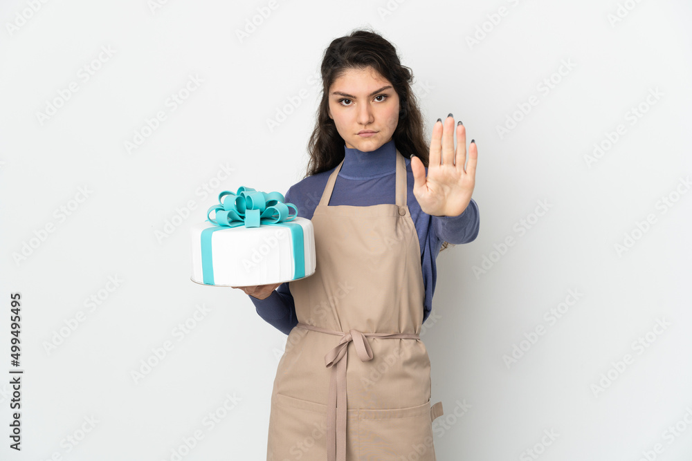 Pastry Russian chef holding a big cake isolated on white background making stop gesture Pastry Russian chef holding a big cake isolated on white background making stop gesture