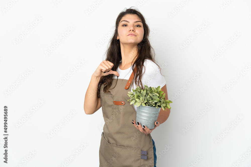 Young Russian gardener girl holding a plant isolated proud and self-satisfied Young Russian gardener girl holding a plant isolated proud and self-satisfied
