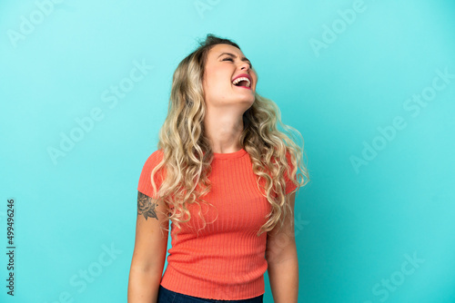 Young Brazilian woman isolated on blue background laughing