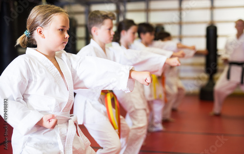 Foto Preteen girl wearing in kimono attempting to master new moves in sport gym