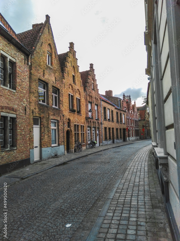 Historical street with medieval brick houses in Bruges town, Belgium