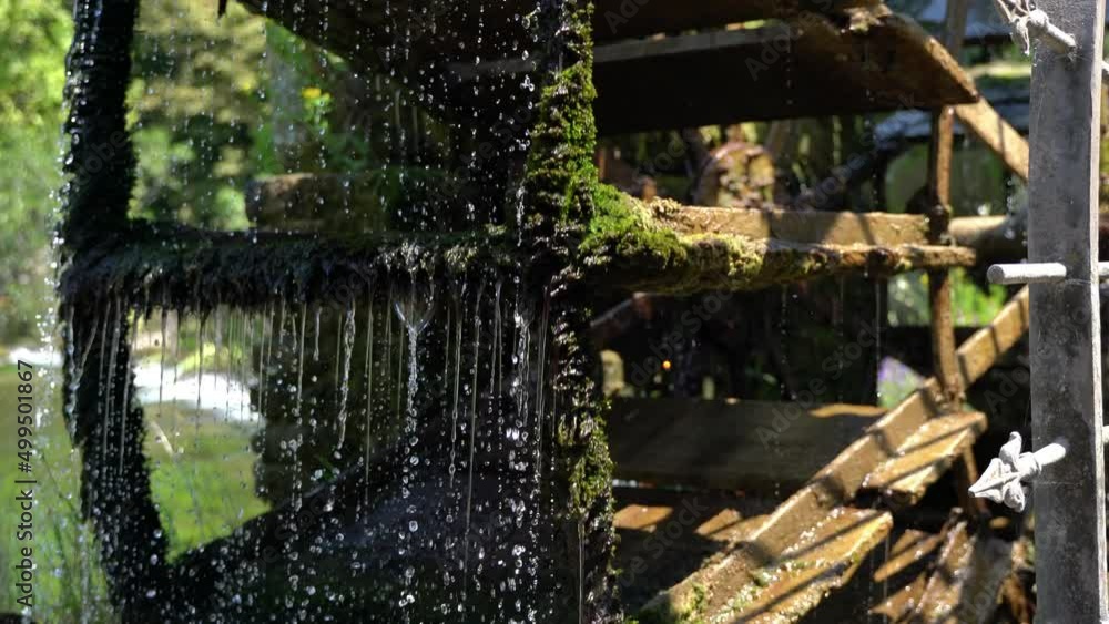 A beautiful, old mill wheel in a colorful garden. A beautiful, old mill wheel in a colorful garden.
