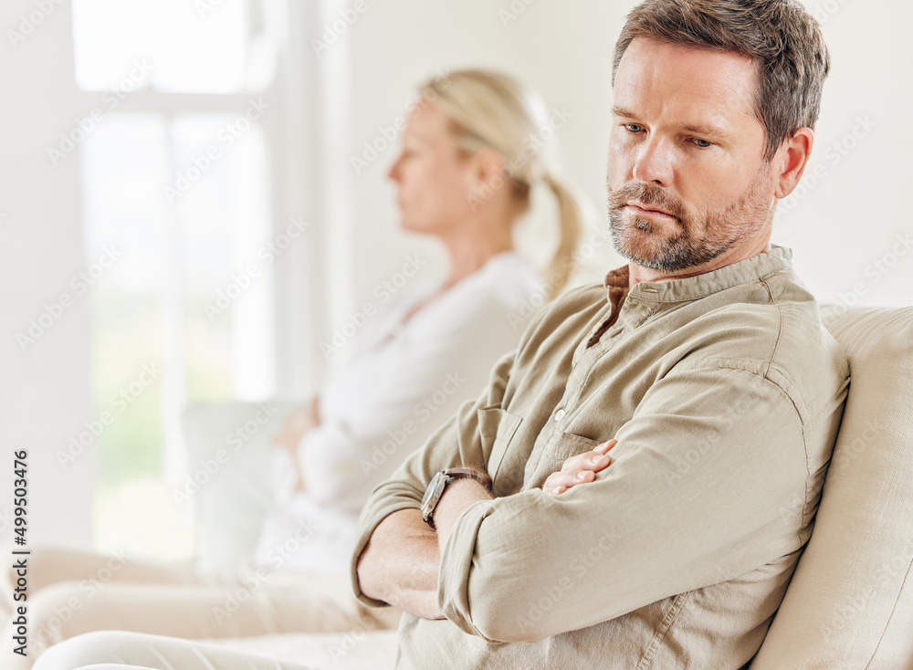 Regrets are relentless. Shot of a young couple looking annoyed after a disagreement on the sofa at home. Regrets are relentless. Shot of a young couple looking annoyed after a disagreement on the sofa at home.