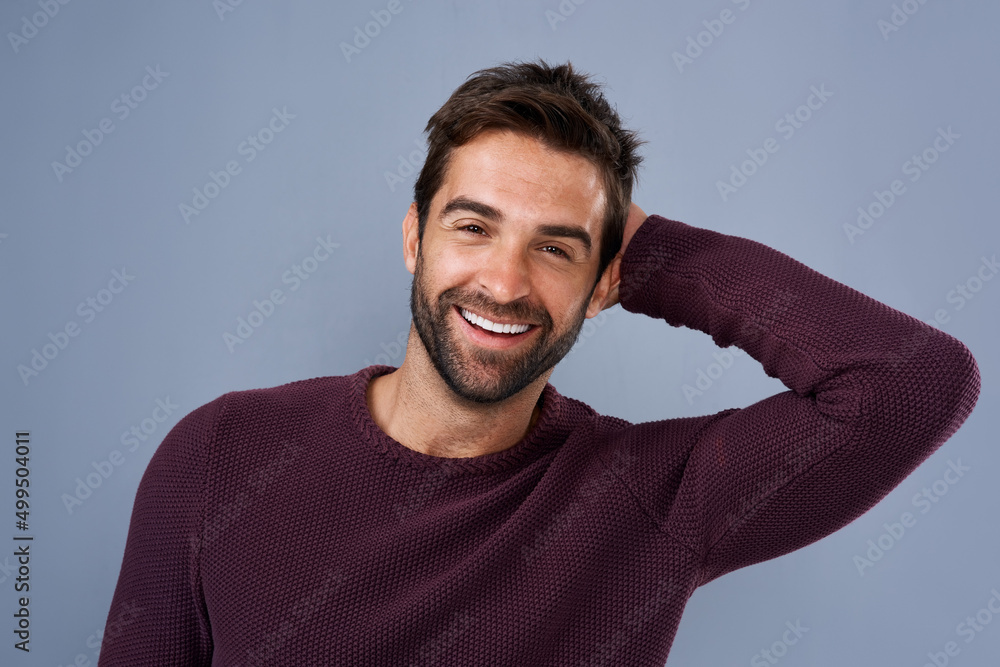 Hes all confidence and positivity. Studio shot of a handsome and happy young man posing against a gray background. Hes all confidence and positivity. Studio shot of a handsome and happy young man posing against a gray background.